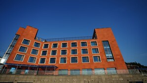 Moderni rakennus, jossa on geometrisesti muotoiltu julkisivu, useita ikkunoita ja tasakatto.