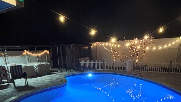 Piscina à noite com luzes de corda.