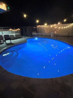 A swimming pool at night with string lights. -  Salt Pool, cozy House near Downtown and International Airport (Orlando)