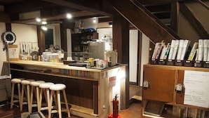 Una cocina con taburetes de madera, una encimera y una estantería llena de libros.