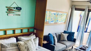 Een hotelkamer met een groot bed, een bank, een klein tafeltje en een schilderij aan de muur.