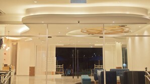 A modern hotel lobby with a circular ceiling design, a seating area with sofas and chairs, and a staircase leading to the upper level. - AVI Pangkor Beach Resort (Pangkor Island)