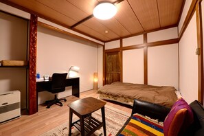 A bedroom with a bed, desk, chair, and a small table. - Azuma Ryokan (Kitakata)