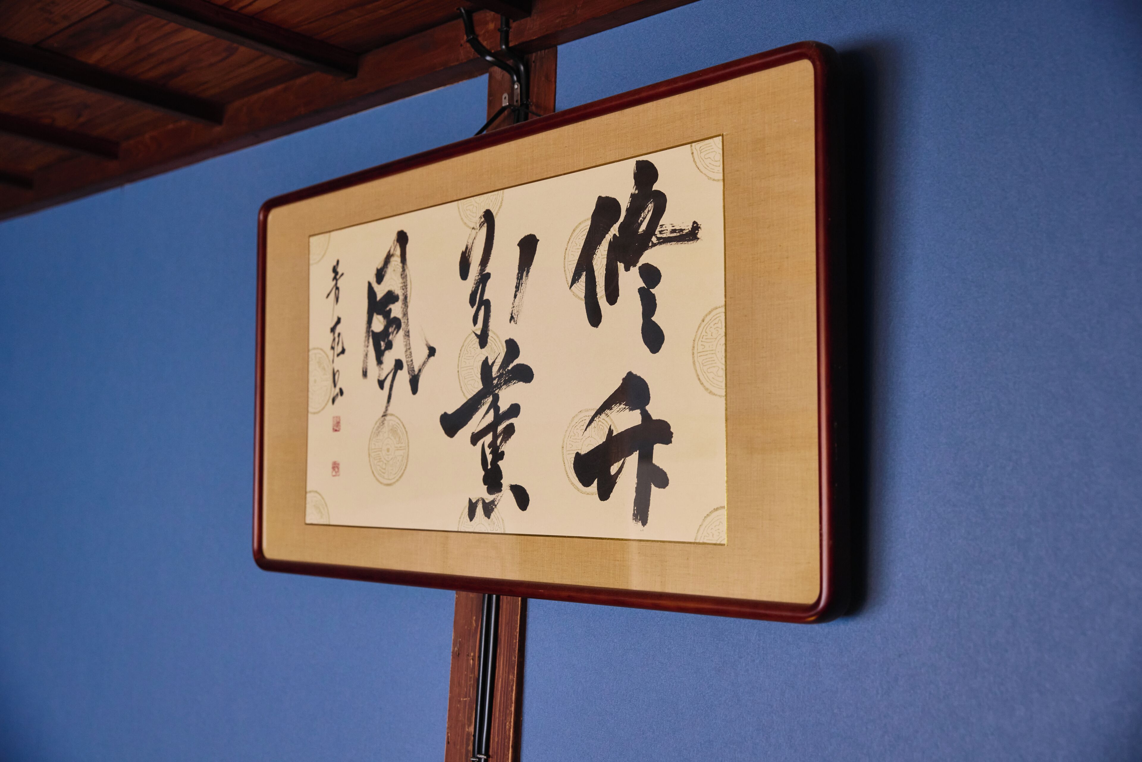 A framed calligraphy piece on a wall.