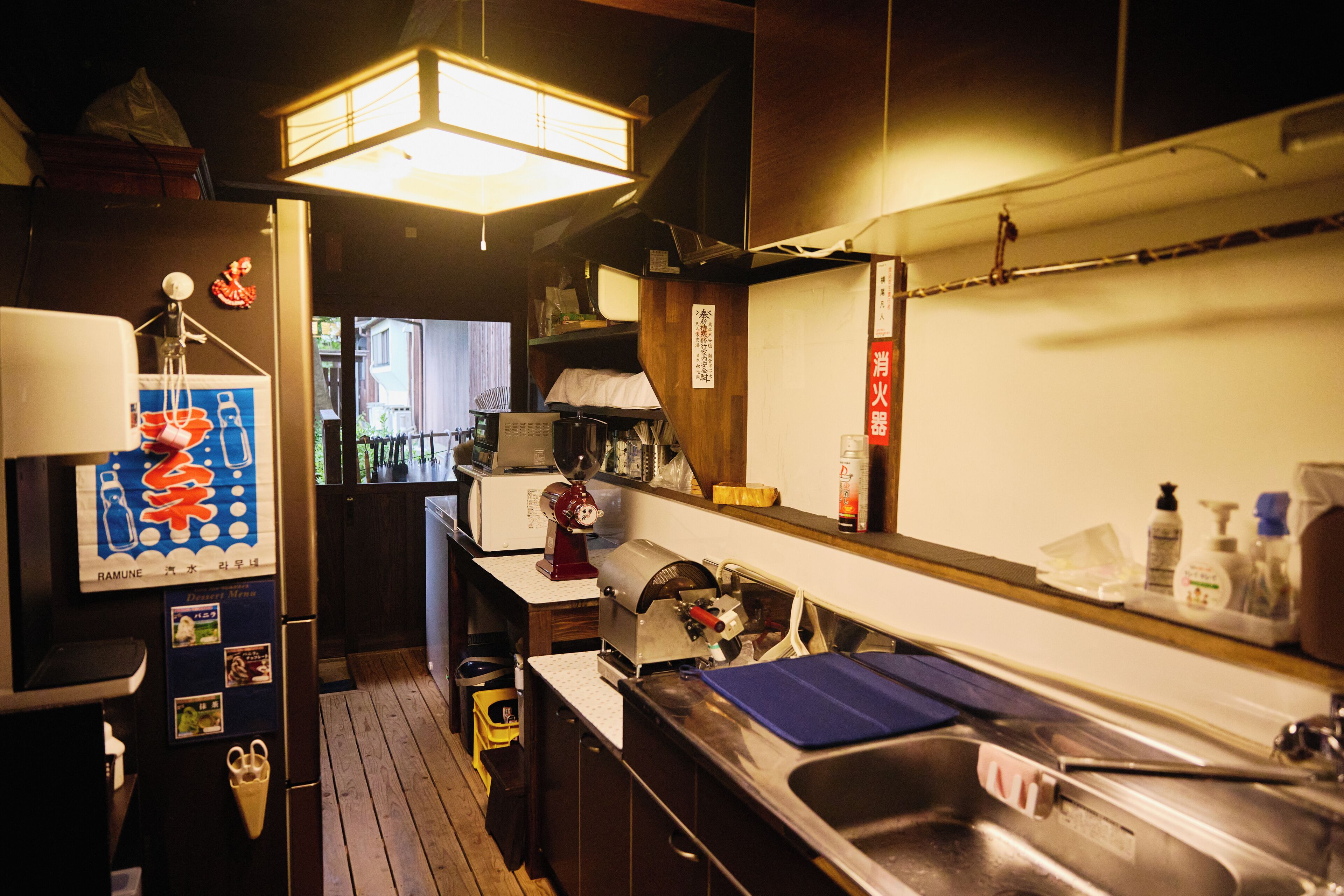 A kitchen with wooden cabinets, a stainless steel sink, and a refrigerator with a water dispenser.
