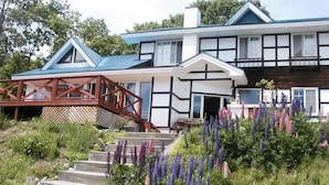 A two-story house with a wooden staircase leading to a porch.
