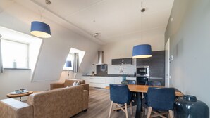 A modern apartment with a dining area, sofa, and kitchen. - Ganuenta by Interhome (Colijnsplaat)