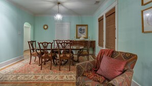 A dining area with a round table and chairs, a chandelier, and a patterned rug. - 3BR 2BA Dynamite Cooper Young Craftsman 2 blocks from Cooper Young intersection! (Memphis)
