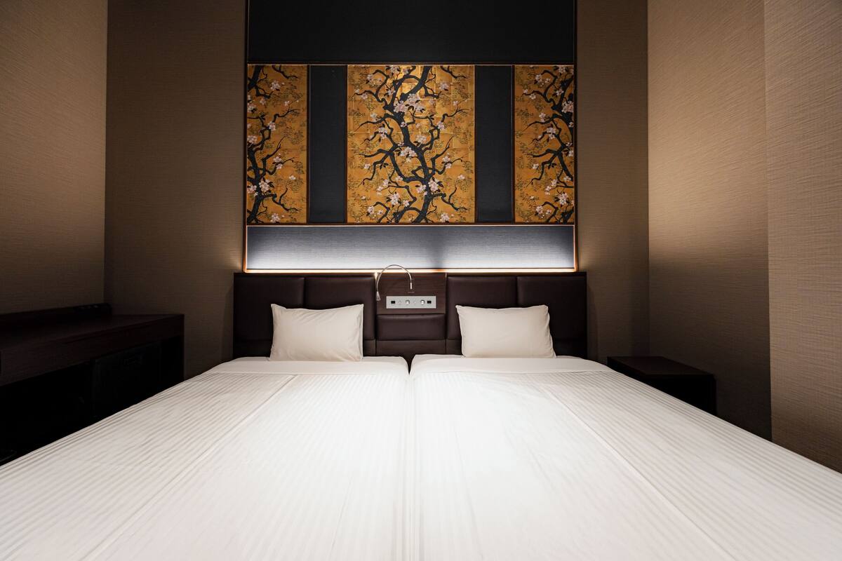 Een hotelkamer met een groot bed, nachtkastjes, een kunstwerk aan de muur en een nachtkastje.