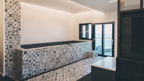 Una cuina moderna amb rajoles decorades, una banca integrada i vista a través d'una porta de vidre.