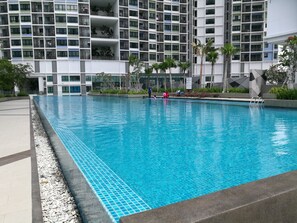 Relax by the pool surrounded by lush greenery and take in the views of the surrounding building.