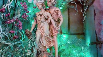 Una estatua de dos figuras en un arco de piedra con adornos festivos.
