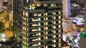 A high-rise building with multiple floors, each illuminated by interior lights.