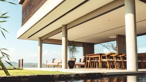 Un edifici modern amb piscina, espai d'estar a l'exterior i una vista despejada del paisatge circumdant.