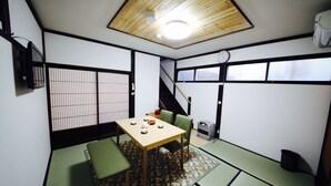 A traditional Japanese-style room with tatami flooring, a low table, and green cushions. - Utatei Takayama (Takayama)