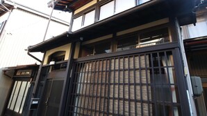A traditional Japanese house with a wooden upper floor and a black gate. - Utatei Takayama (Takayama)
