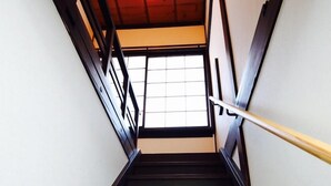 A wooden staircase with a handrail, leading to a room with a window. - Utatei Takayama (Takayama)