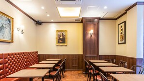 Een restaurant met een zitgedeelte met tafels en stoelen, en houten tafels.