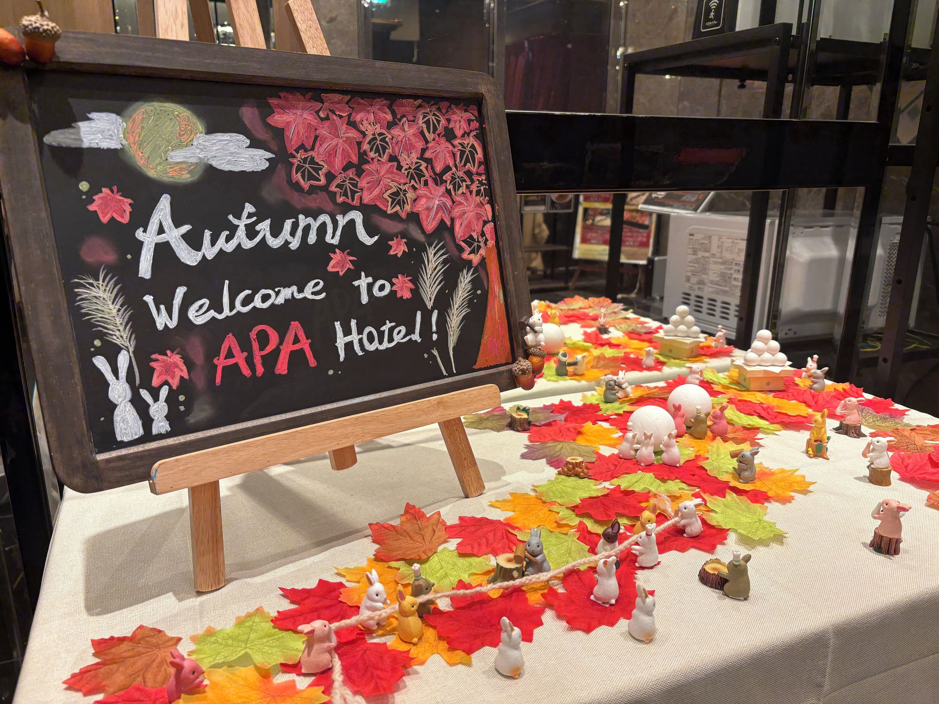 Eine Kreidetafel begrüßt Gäste des APA Hotels mit herbstlicher Dekoration.