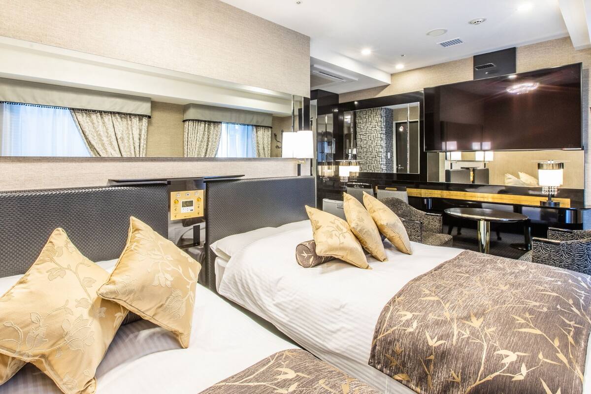 Une chambre d’hôtel avec un grand lit, un bureau, une chaise, un miroir et une télévision.