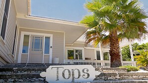 Ein Haus mit einem Schild, auf dem 'Tops' steht, vor einer Steintreppe.