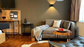 Suite, balcón | Área de sala de estar | Televisión de pantalla plana