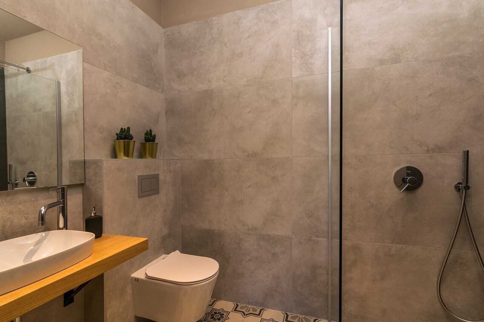 Un baño moderno con un lavamanos grande, inodoro y ducha.