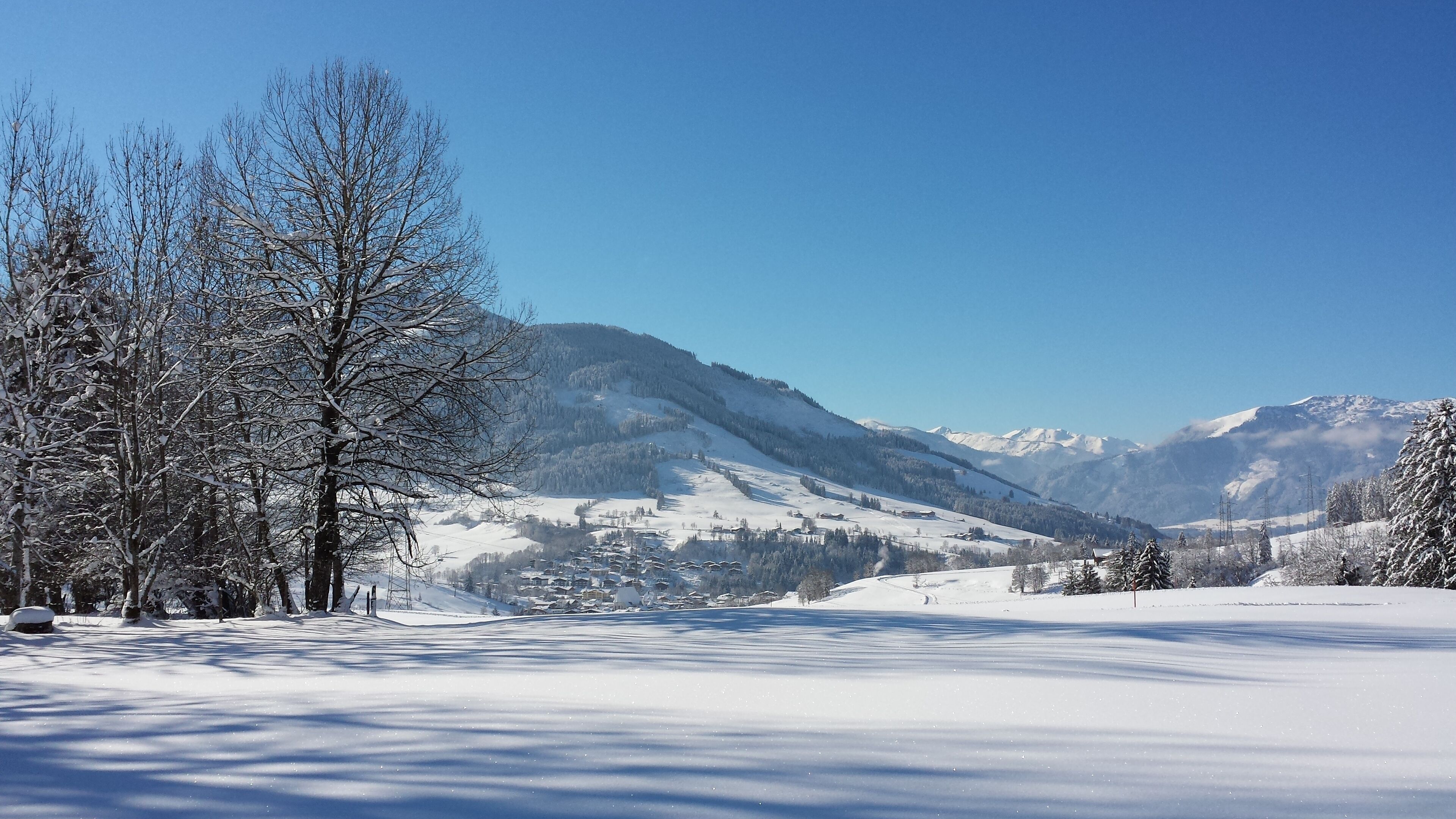 A snow-covered landscape with mountains in the background and a clear sky.