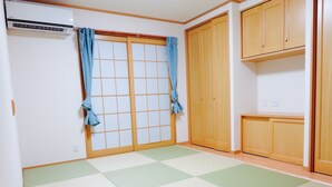 A room with tatami mat flooring, a sliding shoji door, and wooden cabinets. - Utatei Villa (Takayama)