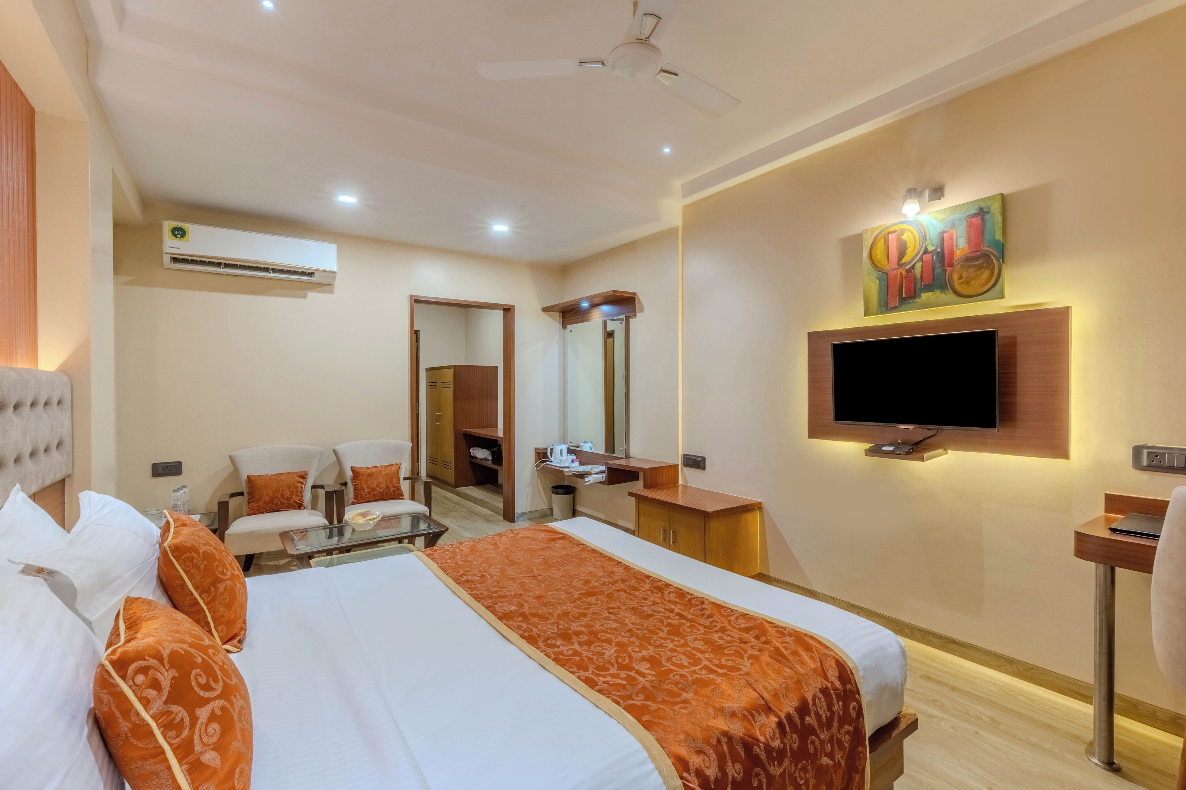 Une chambre d’hôtel avec un lit, une télévision, un bureau et une chaise.