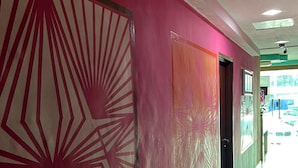 A hallway with a pink wall and a large geometric pattern. - De Glory Hotel USJ 21 (Subang Jaya)