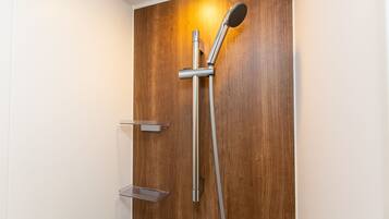 A shower with a wooden panel wall, a handheld showerhead, and a wall-mounted faucet.