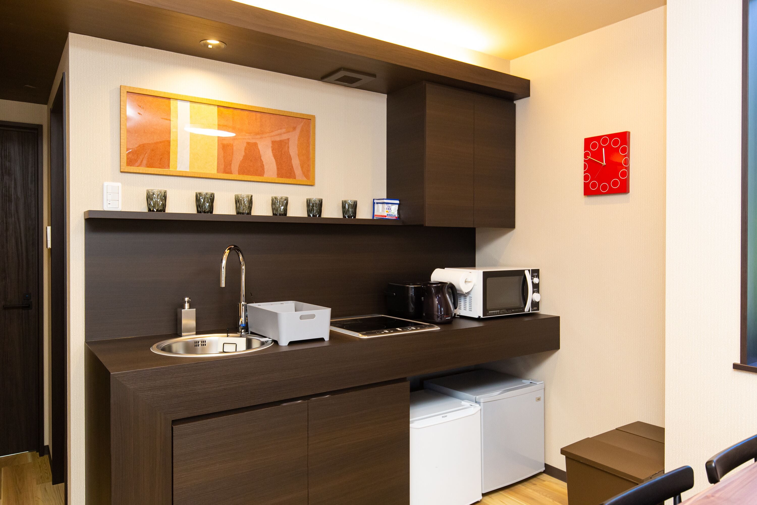 A compact kitchenette with a sink, microwave, and coffee maker.