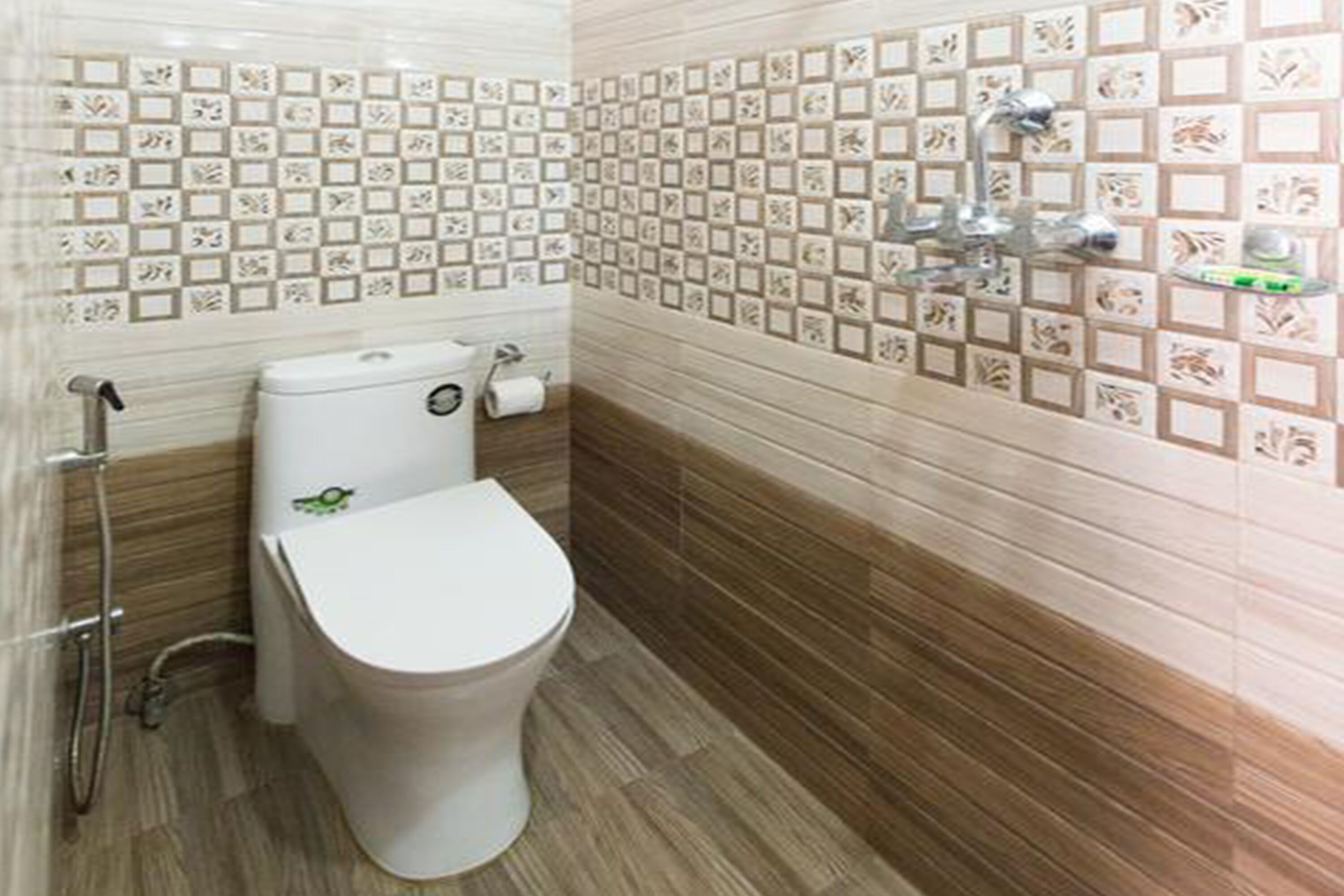 A bathroom with a toilet, a shower, and a wall with patterned tiles.
