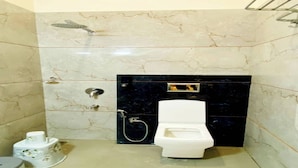 A bathroom with a toilet, a shower, and a sink. - Hotel Grand Paradise (Vadodara)