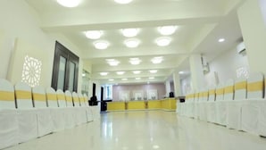 A spacious hall with a high ceiling and multiple round ceiling lights. - Hotel Grand Paradise (Vadodara)