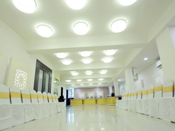 A spacious hall with a high ceiling and multiple round ceiling lights. - Hotel Grand Paradise (Vadodara)