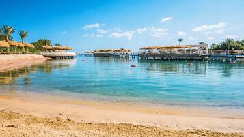 Aan een privéstrand, ligstoelen, parasols, strandlakens
