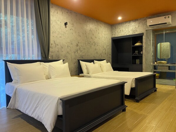 A hotel room with two beds, a built-in shelf, an air conditioning unit, and a bathroom with a mirror and sink. - Ba Ho Eco Beat (Nam Ninh Hoa)
