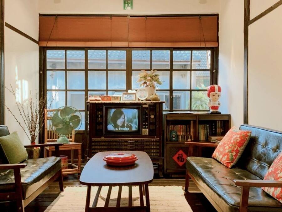 A traditional Japanese-style room with tatami mats, a low table, and a television.
