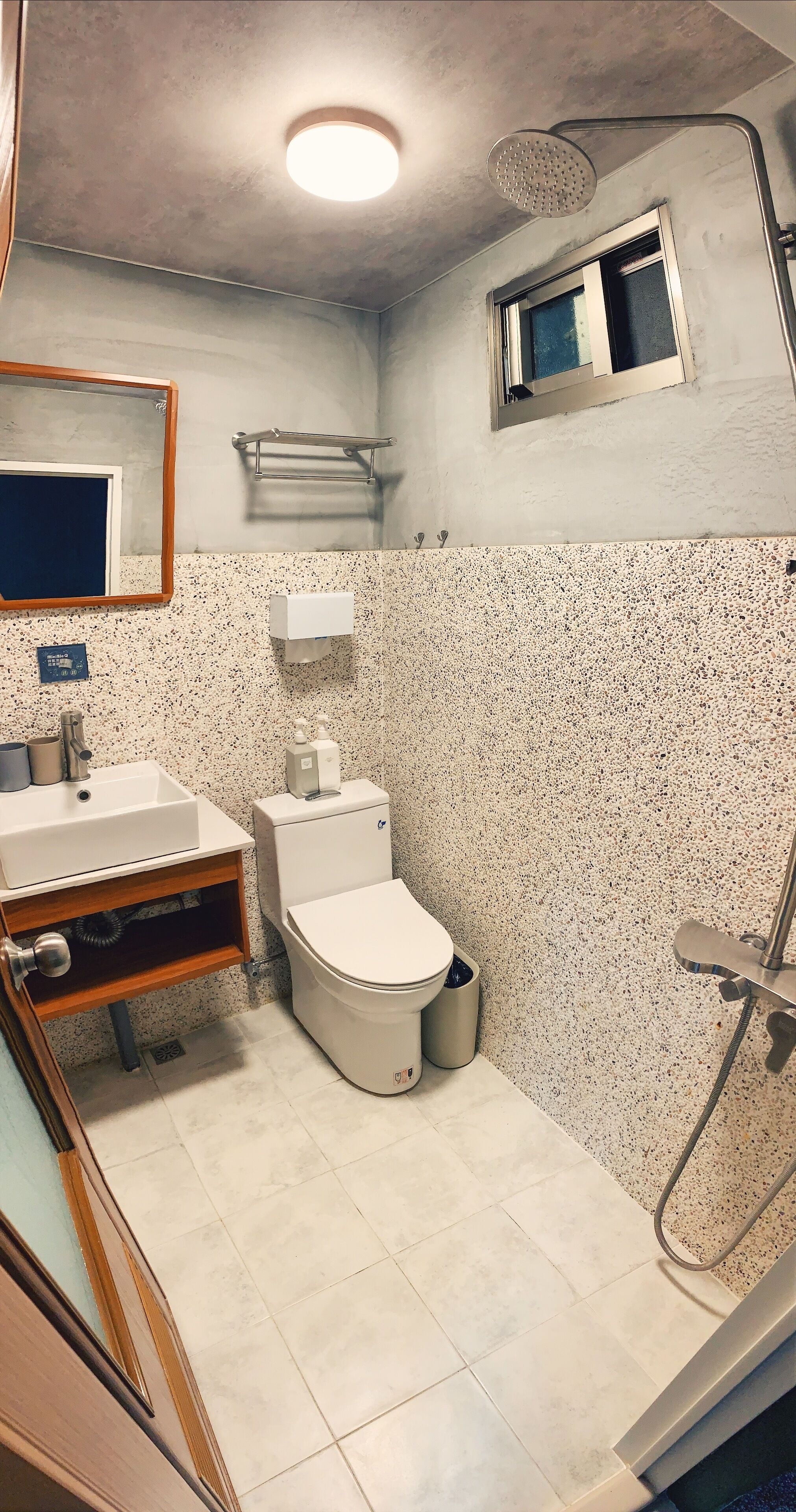A compact bathroom with a toilet, sink, and shower.