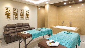 A spa room with a massage table, a massage chair, and a bathtub. - Del Cielo Villa Seminyak (Keroboken Kelod)