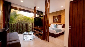 A modern hotel room with a balcony, a TV, a bed, and a round table. - Del Cielo Villa Seminyak (Keroboken Kelod)