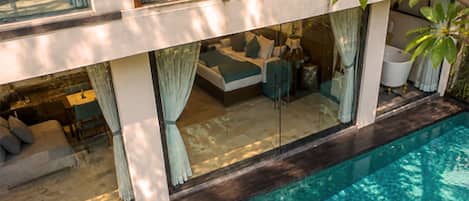 A modern house with a swimming pool, a balcony, and a garden.