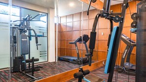 A gym with exercise equipment, a mirrored wall, and a carpeted floor. - Del Cielo Villa Seminyak (Keroboken Kelod)