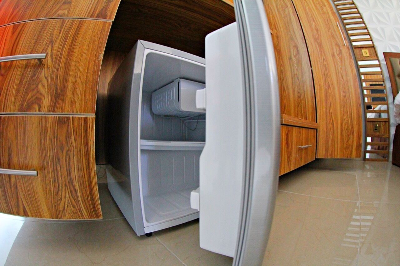 A modern kitchen with wooden cabinetry and a built-in refrigerator.
