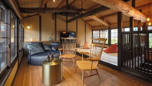 Un intérieur en bois avec un canapé, des fauteuils et une table ronde.