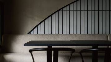 A modern interior with a curved wall, a sofa, and a table with chairs.