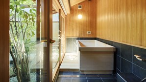 Une salle de bain moderne avec des murs en bois, une porte en verre et un lavabo.