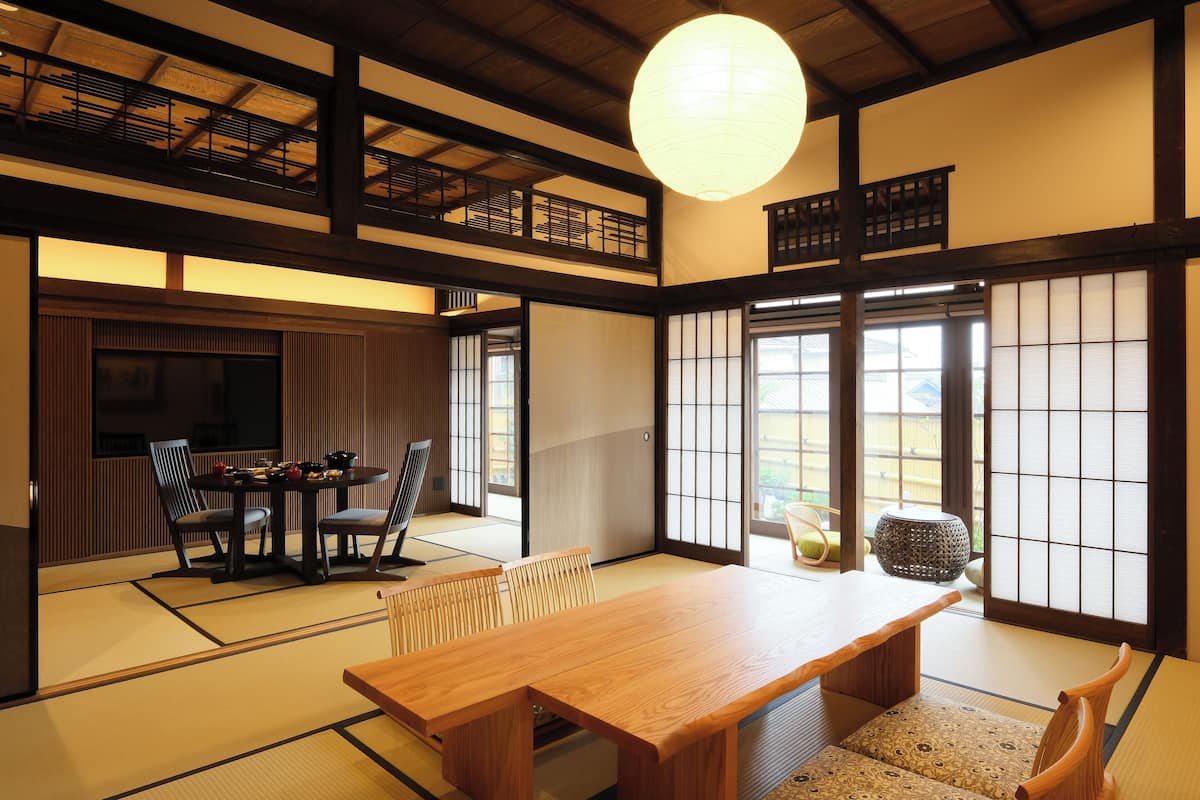 A traditional Japanese room with tatami flooring, a wooden table, and sliding doors.